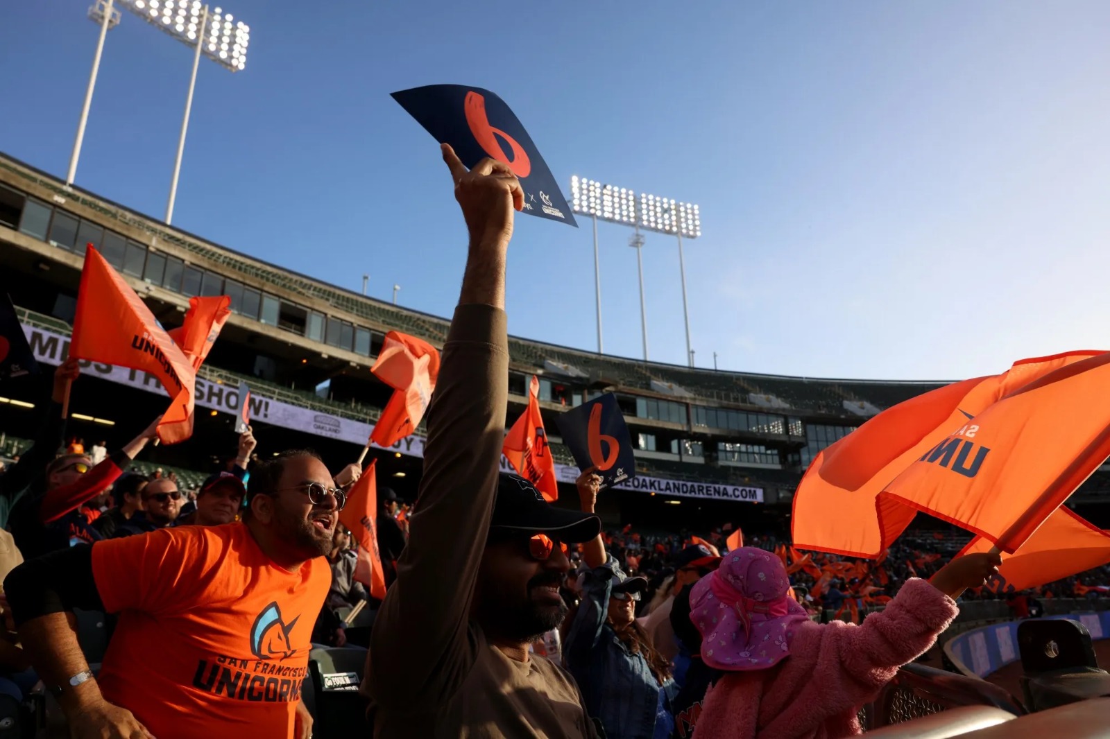 Sparkle Army fans waving orange flags in the stands